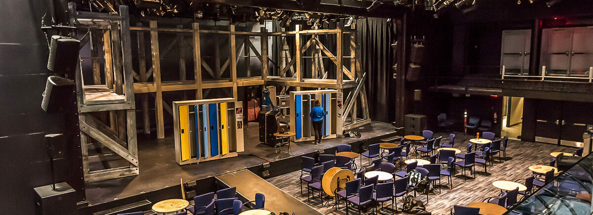 Sheridan Theatre with stage, tables and chairs during set-up